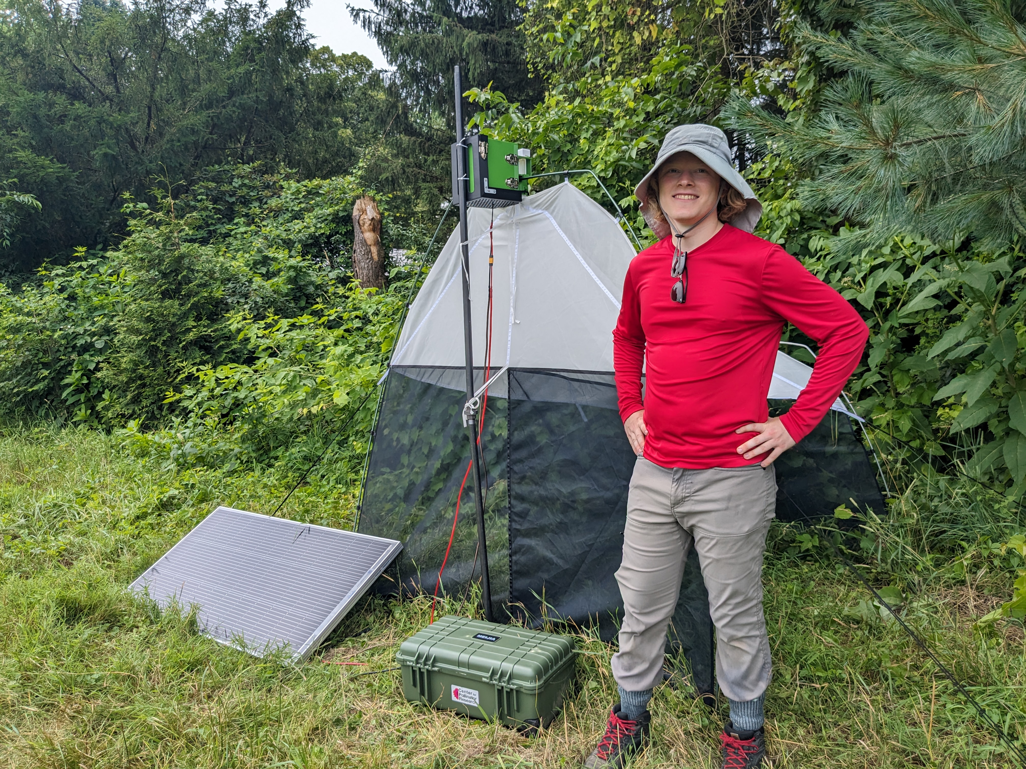 Zachary Bunch standing with the InsectEye unit in the field